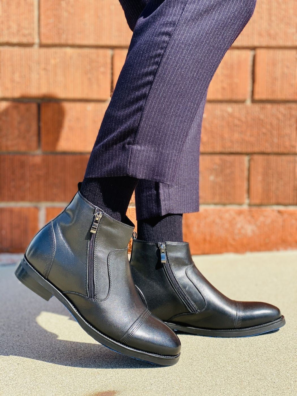Black zipper ankle boots worn with jeans, side view