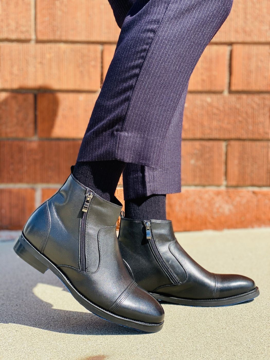 Black zipper ankle boots worn with jeans, side view