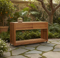 Outdoor teak kitchen island with drawer, open lower shelf, and slatted side panels