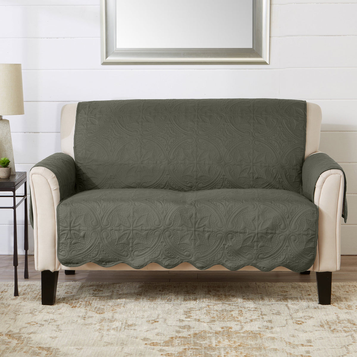 Green recliner protector cover with quilted medallion pattern and beige upholstered arms