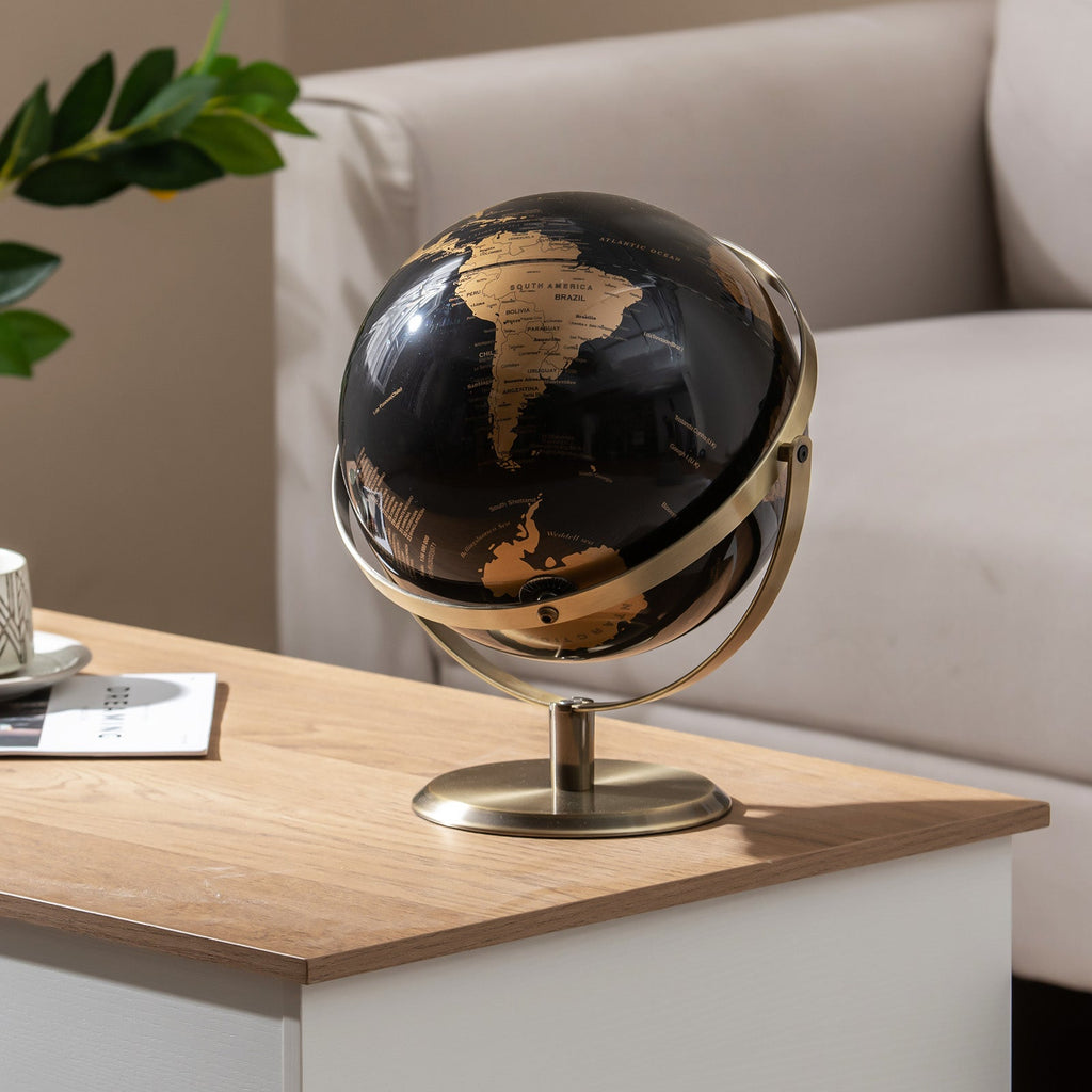 Metallic black world globe on gold metal stand with curved ring frame