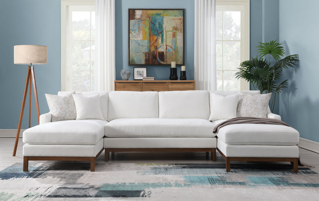 Ivory sectional sofa with chaise, four throw pillows, and dark wood arms