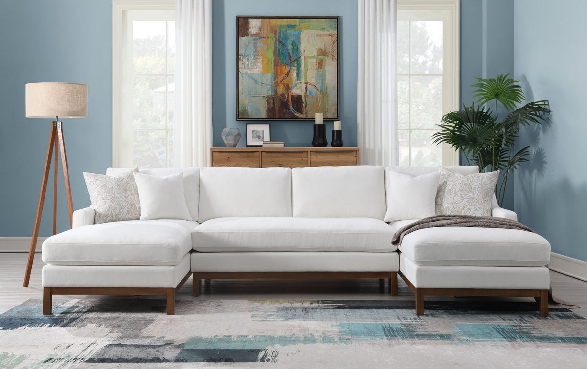 Ivory sectional sofa with chaise, four throw pillows, and dark wood arms