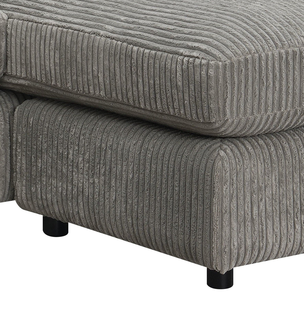 Gray corduroy-textured sectional sofa arm and seat cushion close-up with piping