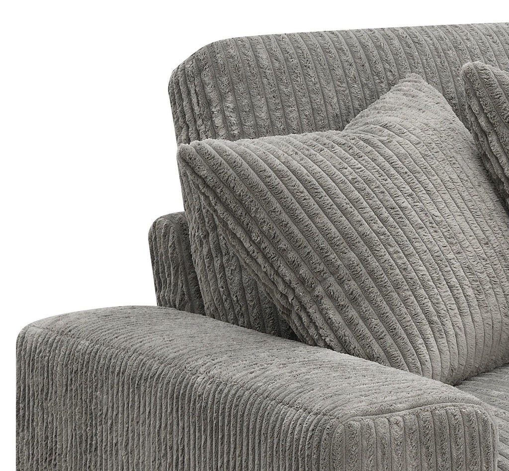 Gray sectional sofa corner with textured throw pillows and padded armrest