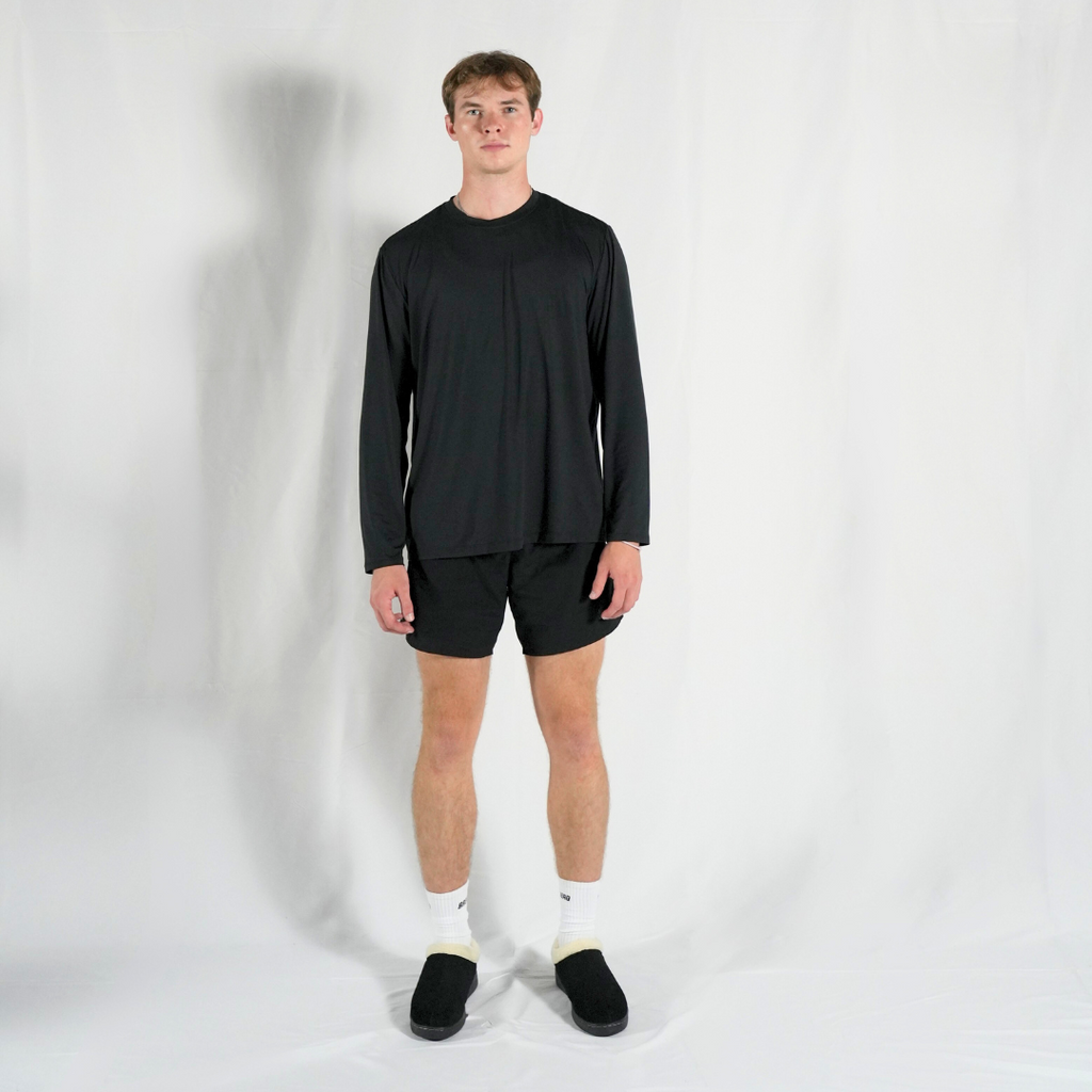 Men's black slippers with cream fleece collar, worn