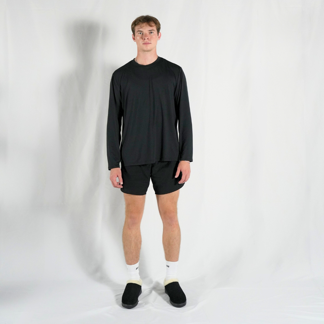 Men's black slippers with cream fleece collar, worn
