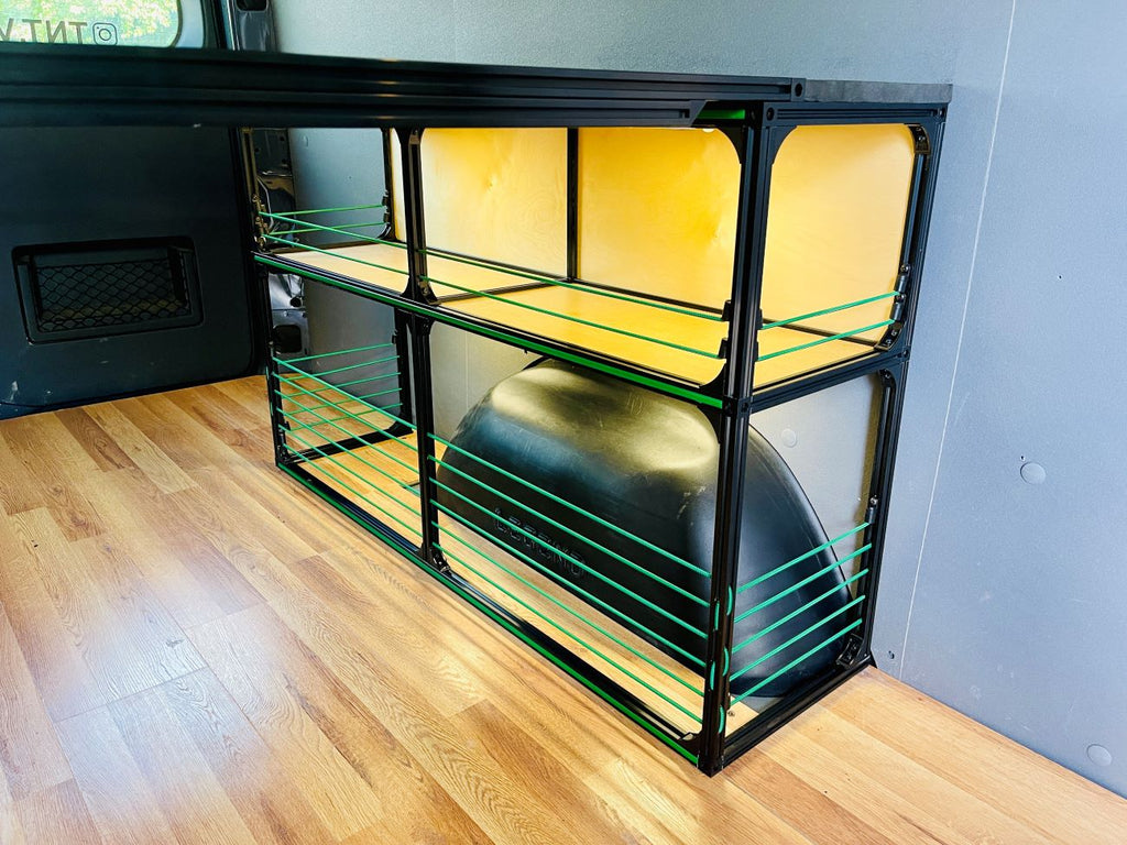 Convertible van bed with light wood platform and green-accent wire shelving storage