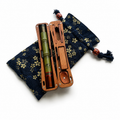 Pocket travel fishing kit with dark blue patterned pouch, tan wooden case, and green rods