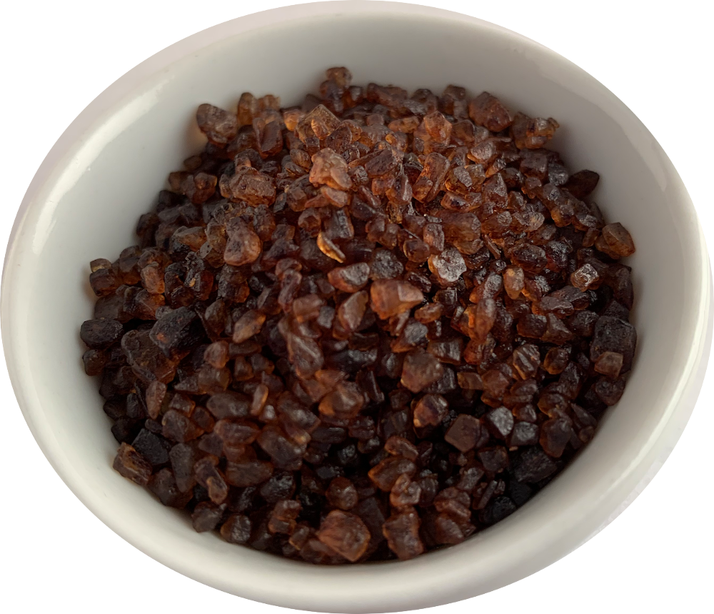 Bowl of smoked sea salt crystals, dark amber-brown granules