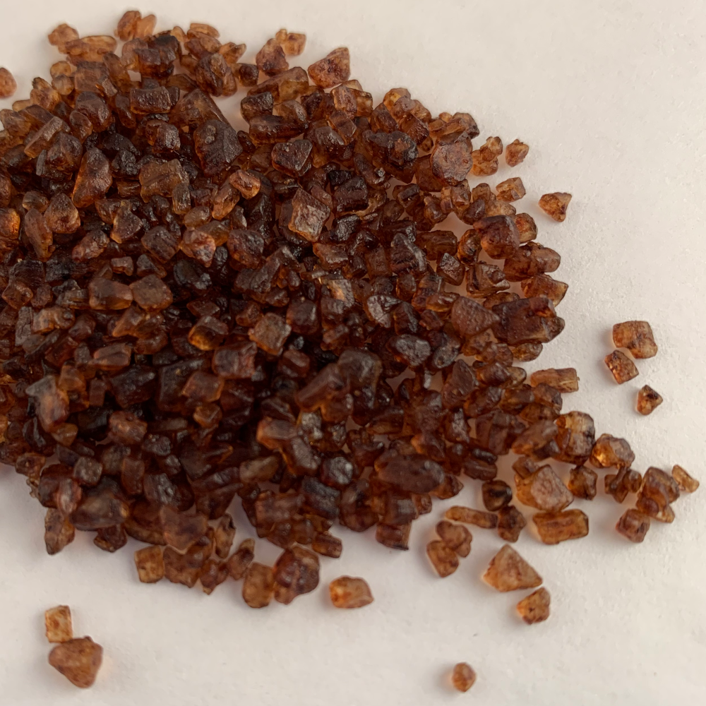 Close-up of smoked sea salt crystals, dark amber-brown coarse grains