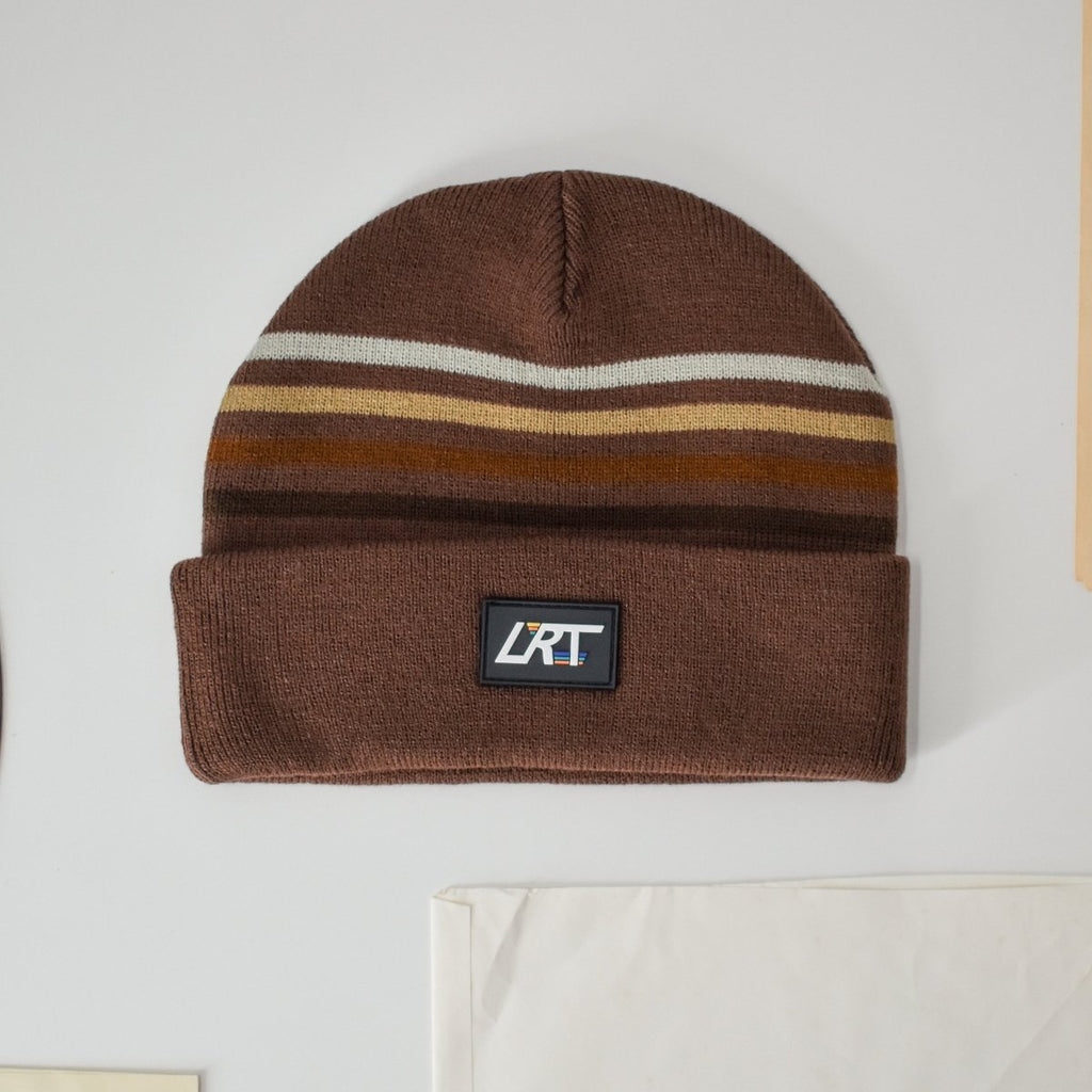 Brown knit beanie with horizontal stripe band and front logo patch detail
