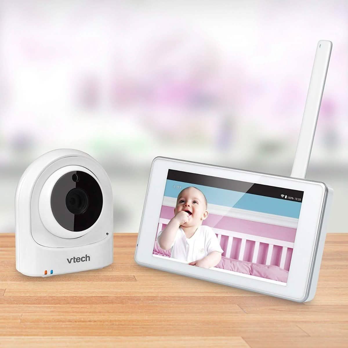 White Wi-Fi baby video monitor with camera unit and tablet screen showing baby
