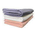 Waffle weave bath towels in charcoal gray, white, and coral folded stack