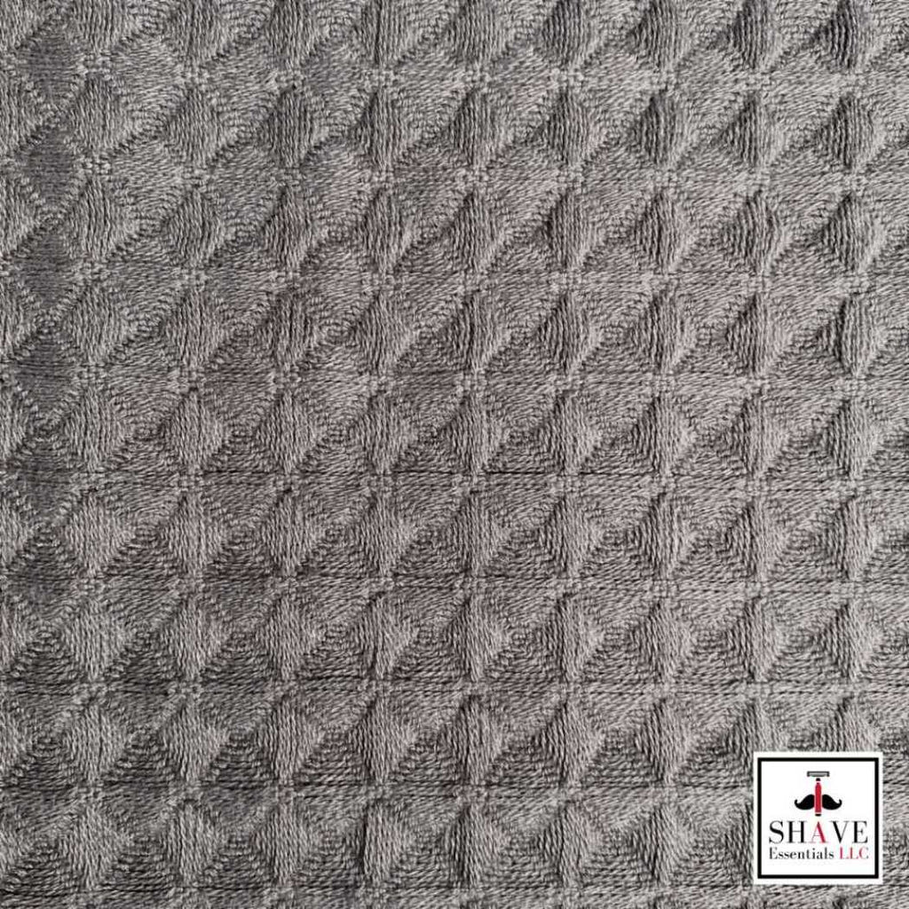 Waffle weave towel fabric close-up in charcoal gray with embossed diamond texture