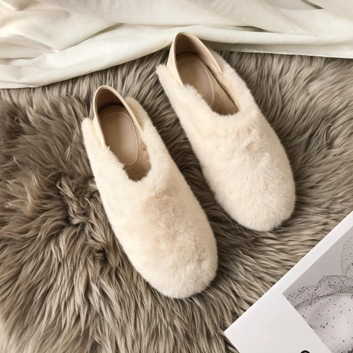 Cream white fuzzy round-toe slip-on loafers with soft faux fur and tan interior lining
