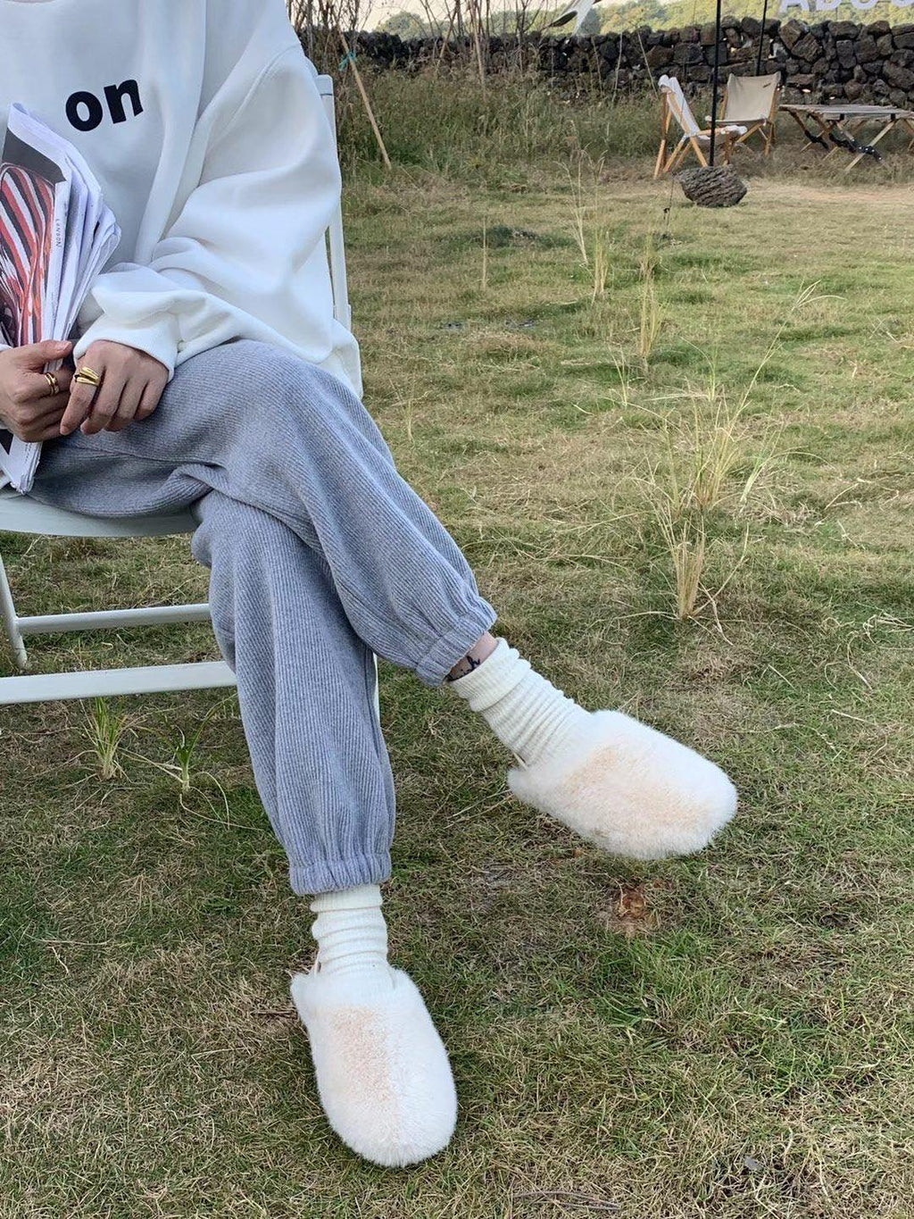 Fuzzy white round-toe loafers, slip-on house slippers worn by model
