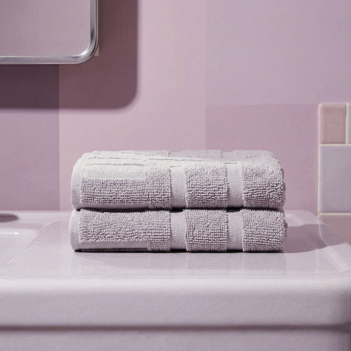 Two stacked light gray cotton towels tied with center stripe bands
