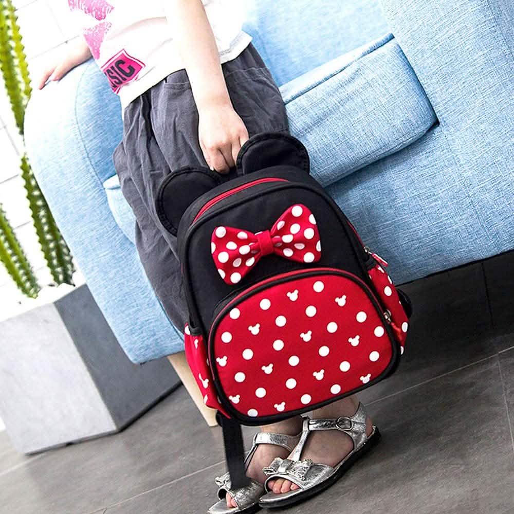 Mini mouse backpack worn by child, front bow and red polka-dot pocket visible