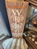 Wooden rustic Welcome sign with vertical WELCOME letters and pumpkin silhouette art