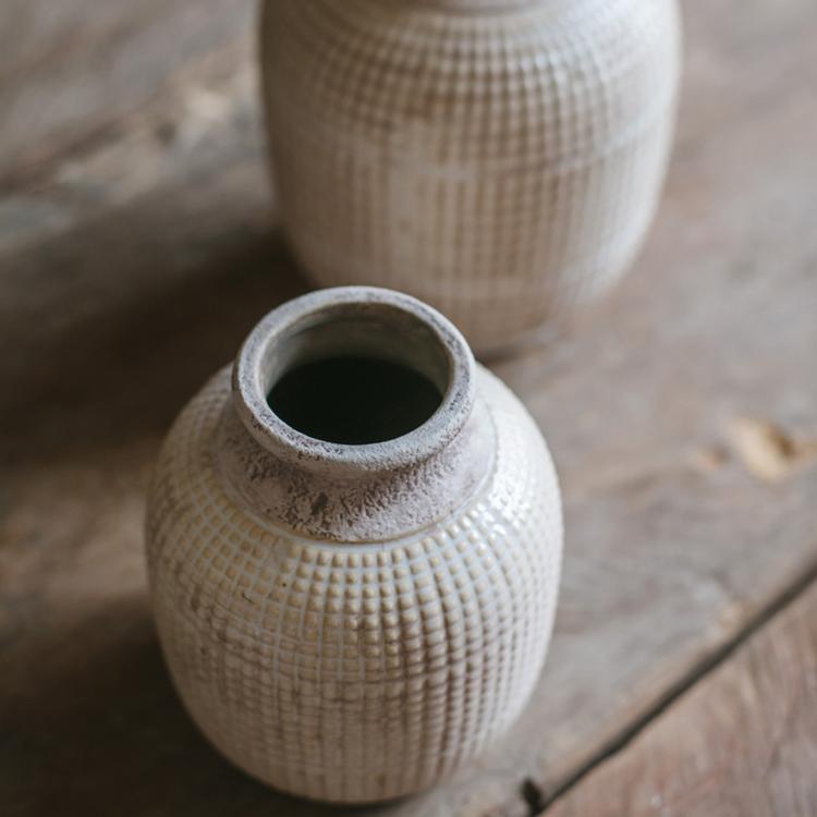 Close-up of textured ceramic jar vase top with open mouth