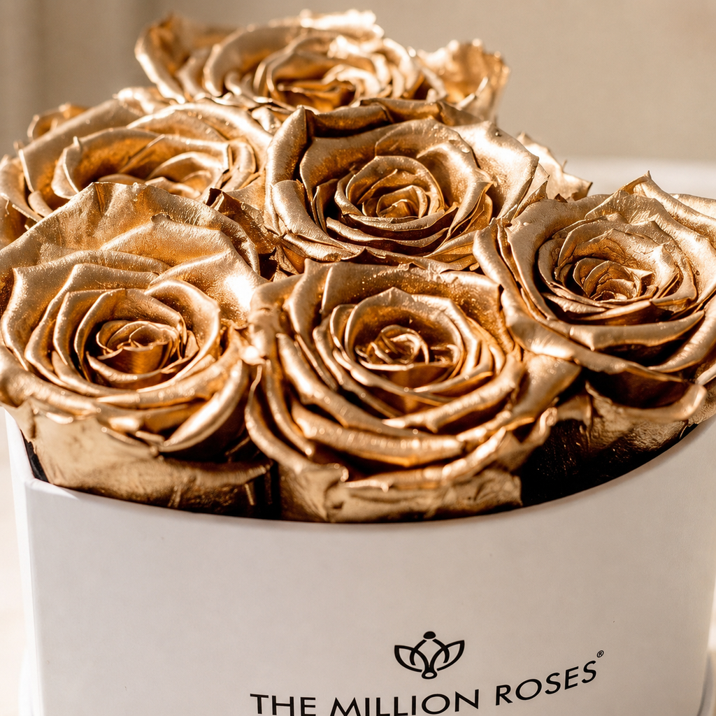 Close-up of gold roses in white round box; THE MILLION ROSES text visible