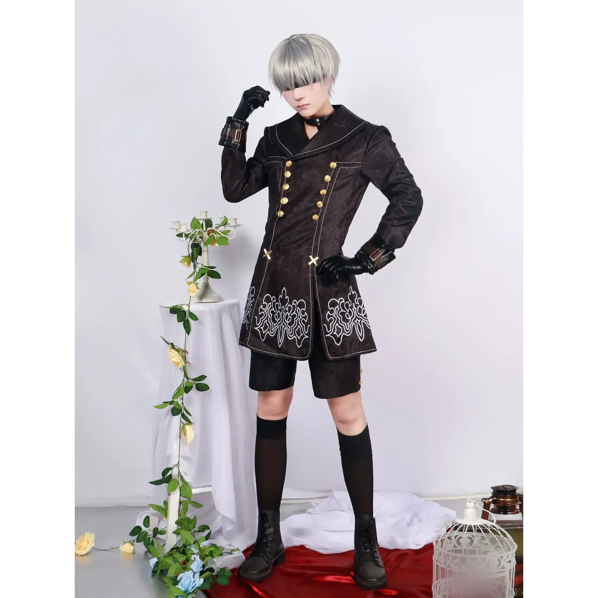 Black 9S cosplay coat with gold details, short shorts, thigh-high socks, and white bob wig