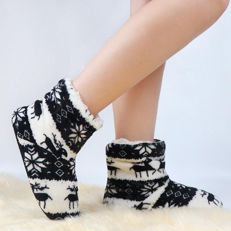 Black and white plush slipper boots with reindeer and snowflake pattern, ankle height