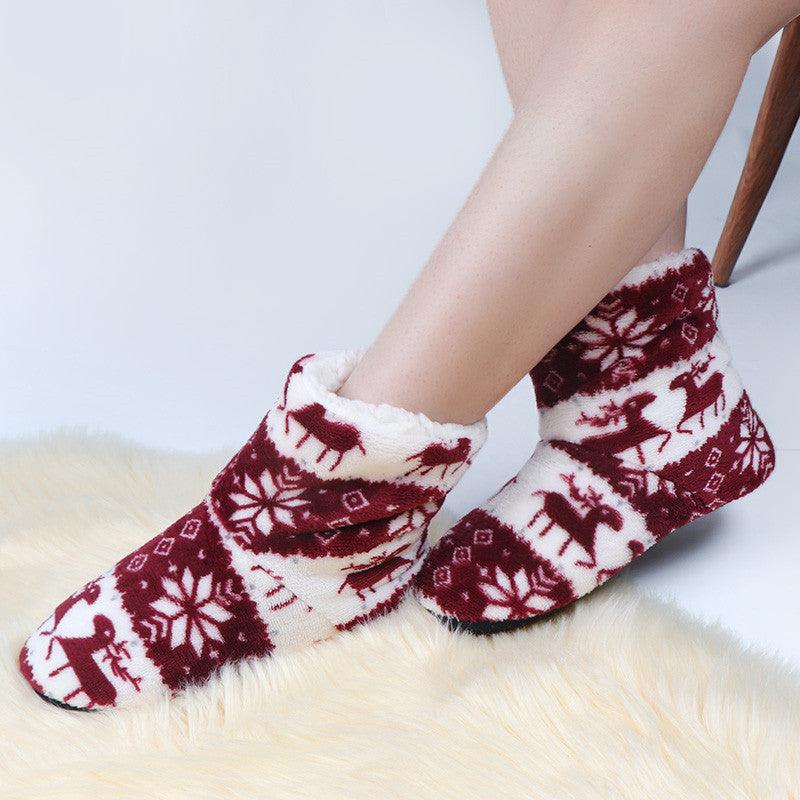 Women’s plush winter slipper boots, maroon and white reindeer pattern on feet