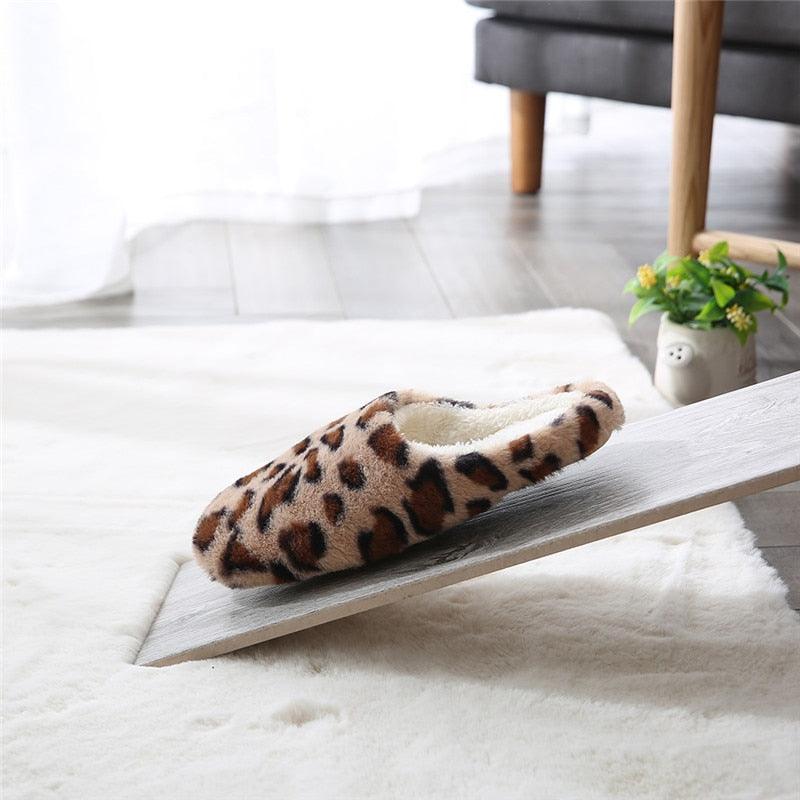 Brown leopard-print plush slip-on slippers on a soft white rug