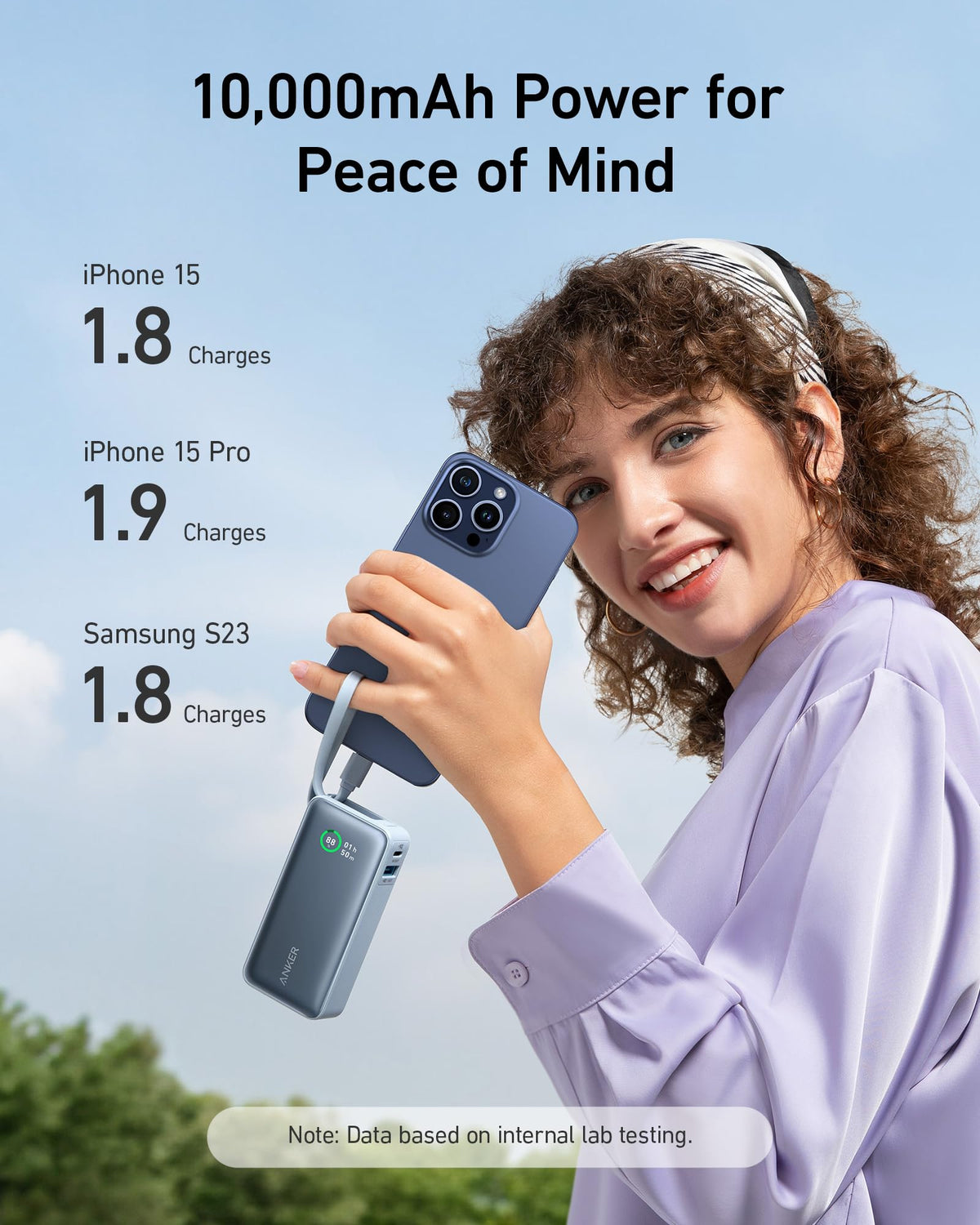 Portable power bank with built-in USB-C cable, light blue, held near a smartphone