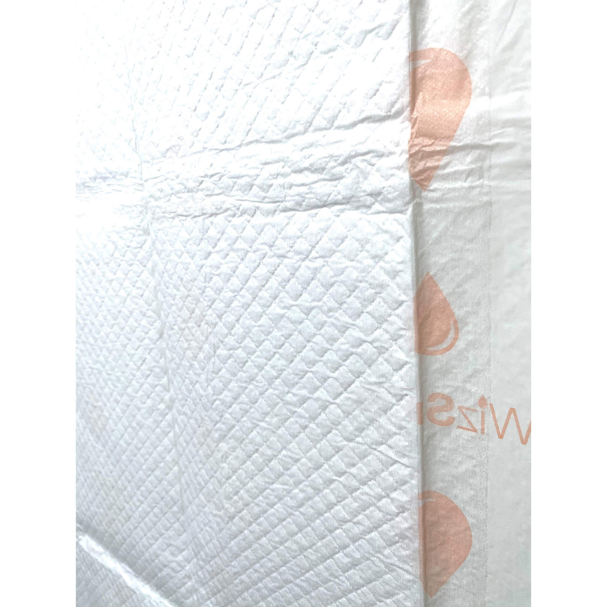 Close-up of white dog training pad surface with embossed texture