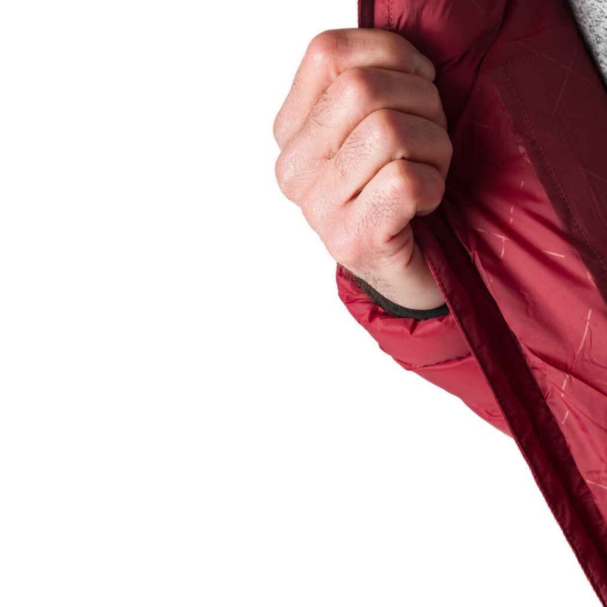Close-up of a dark red heated jacket: hand pulling the zipper on the front