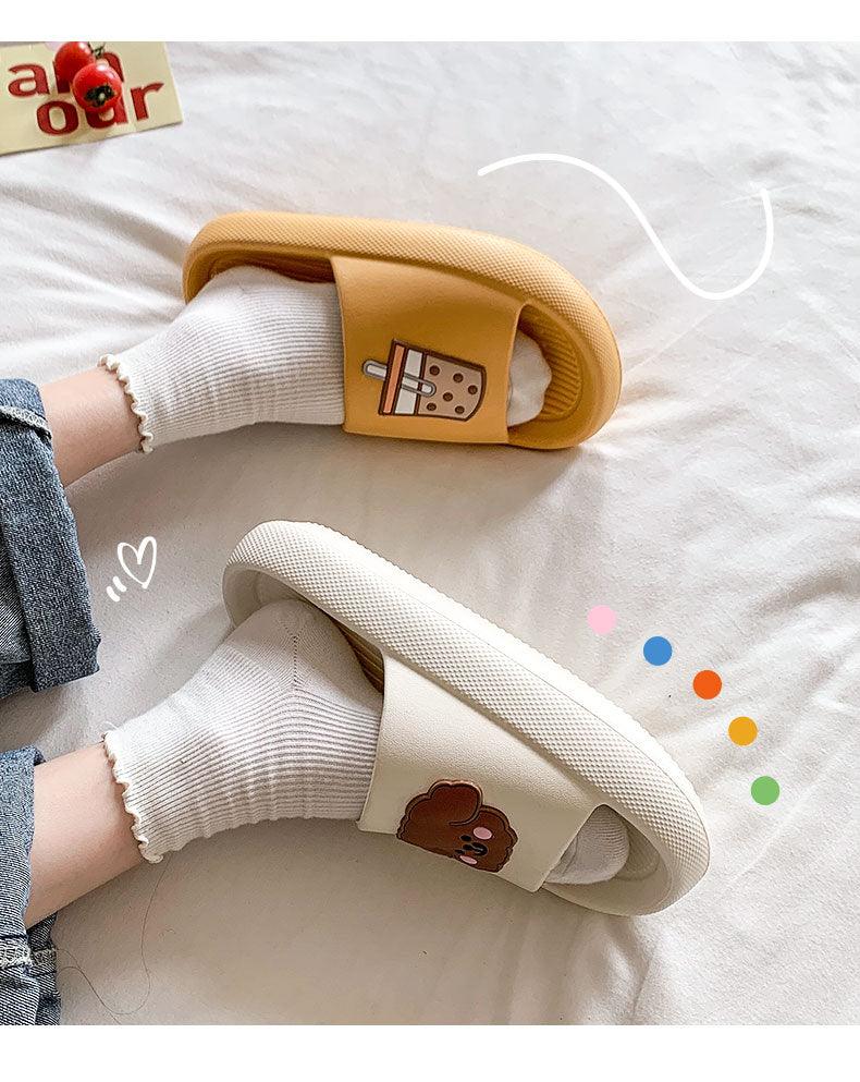 Women’s open-toe slide slippers in cream with paw patch and drink icon, worn with socks