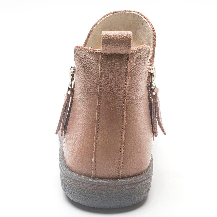 Tan ankle boots close-up with fur lining, side zippers, and tassel details