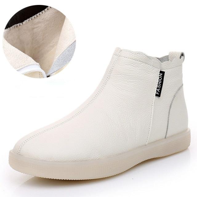 White Chelsea-style ankle boot with “FASHION” side tab and soft fur lining