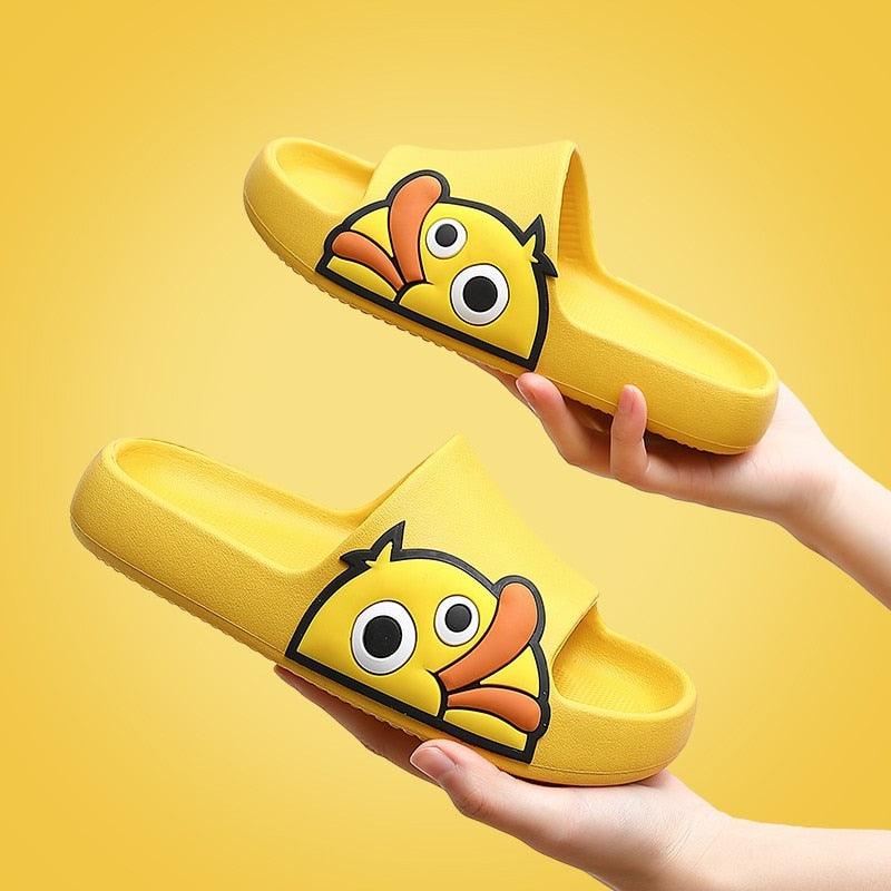 Yellow open-toe slide slippers with cartoon character patch on front