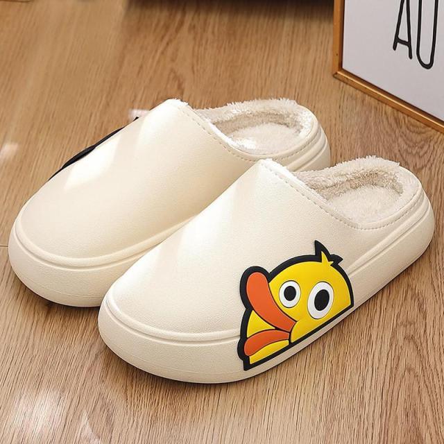 Cream slip-on slippers with plush lining and cartoon character patch on side