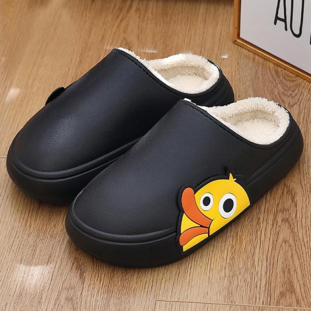 Black slip-on slippers with plush lining and cartoon character patch on side