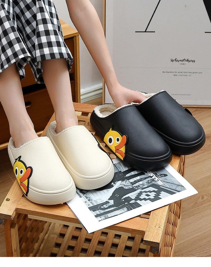 White and black slide slippers with white fleece lining and cartoon character graphic