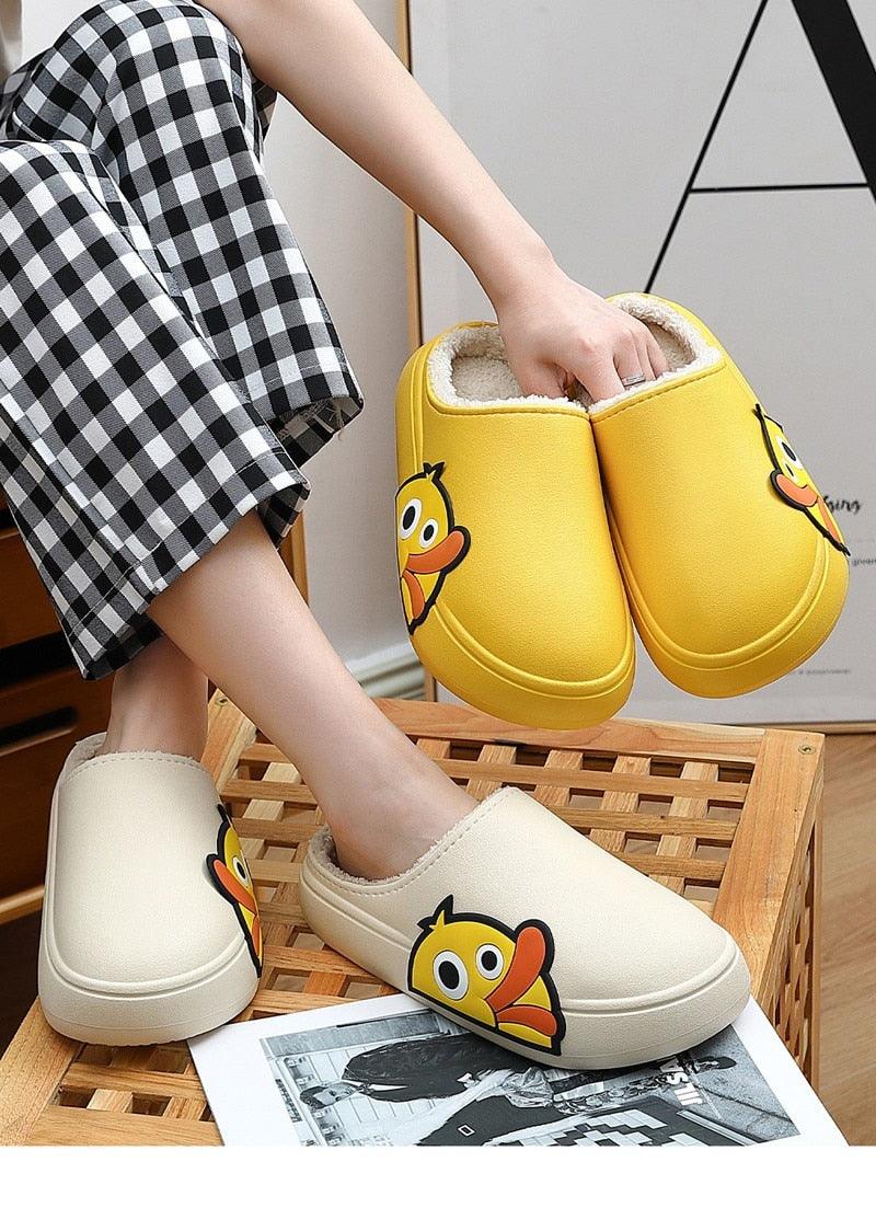 Pair of yellow clogs and white slippers with cartoon character patch on front