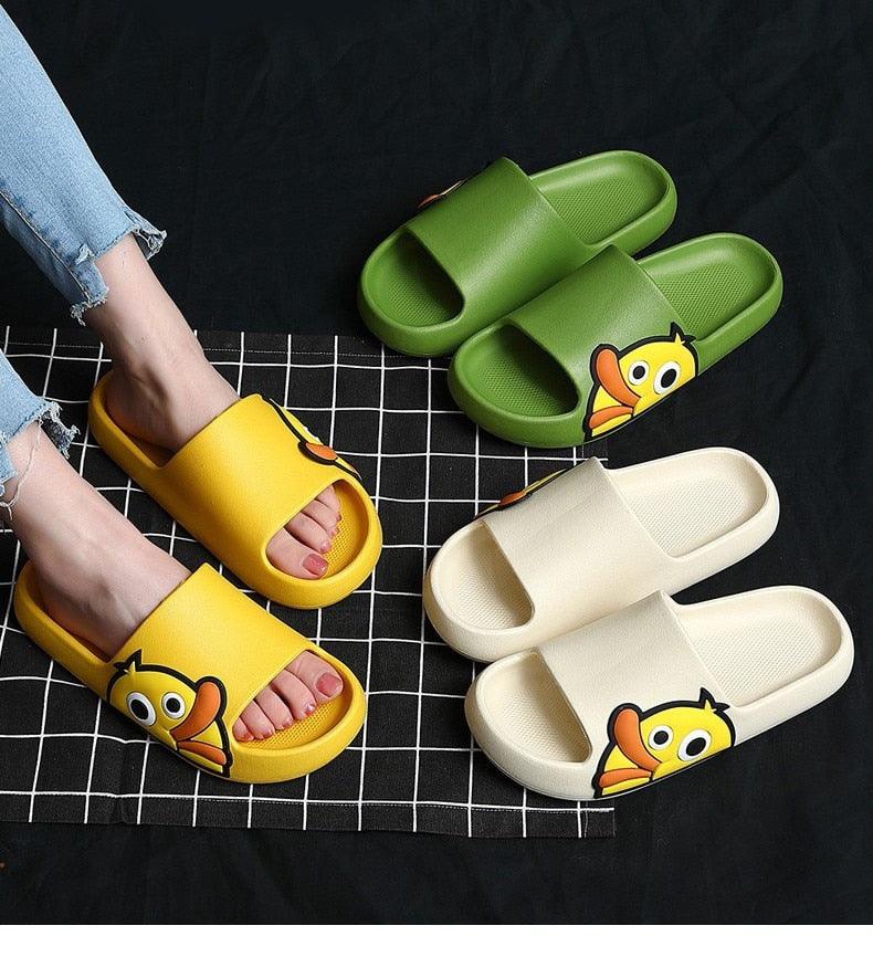 Set of slide slippers in green, yellow, white, and orange with cartoon character logos