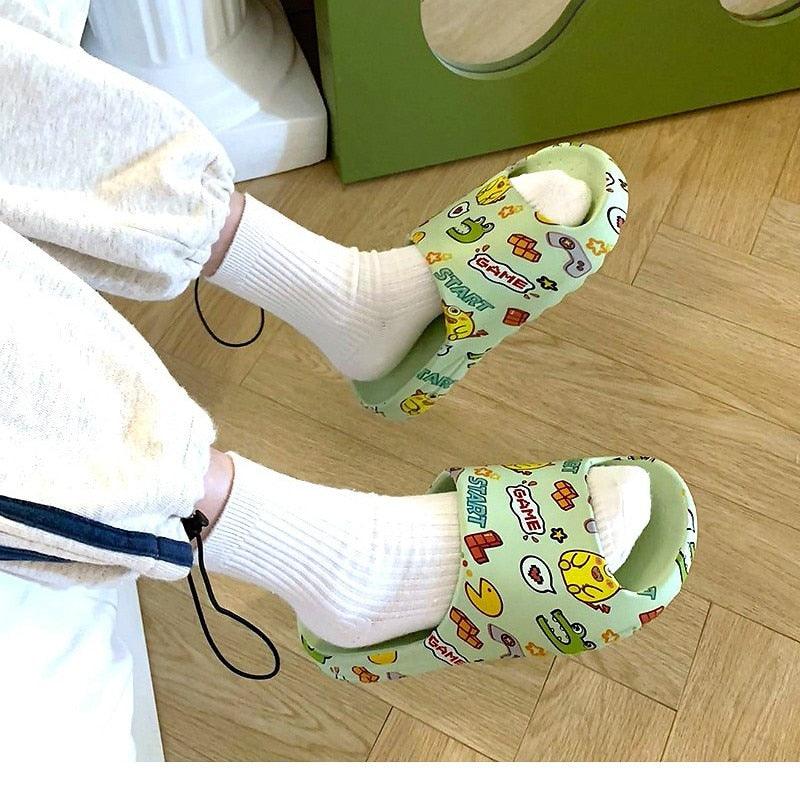 White slide sandals with colorful game icon print, worn with white socks