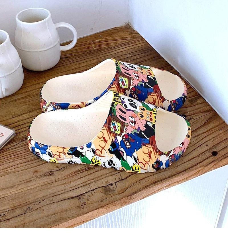 Cartoon slide sandals with multicolor character print, open toe on wooden floor