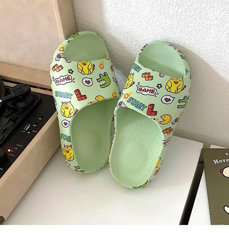 Green-and-white game print slide sandals with open toe and cushioned insole