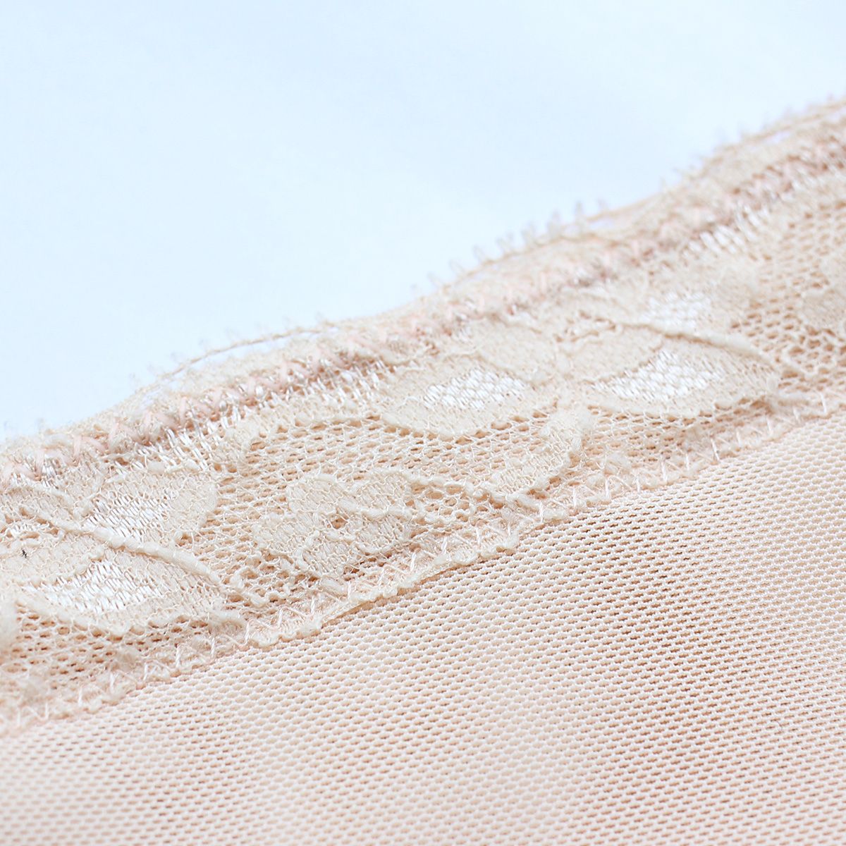 Close-up of skin-tone lace overlay fabric on shaping shorts