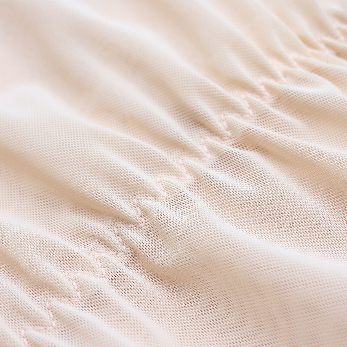 Beige mesh fabric texture on high-waist shaping shorts