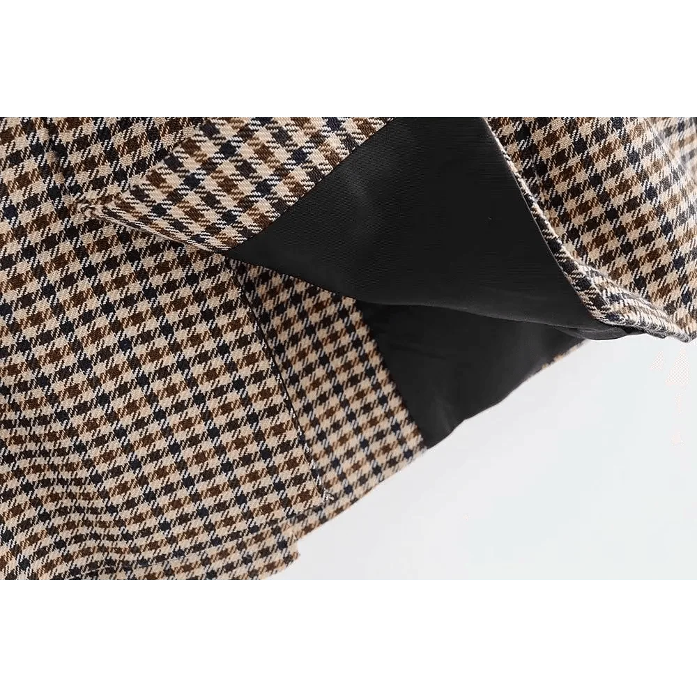 Plaid blazer fabric with dark buttoned cuff detail at the hem