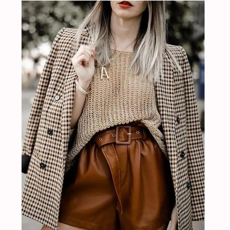 Brown plaid blazer coat sleeve with button detail over a knit top