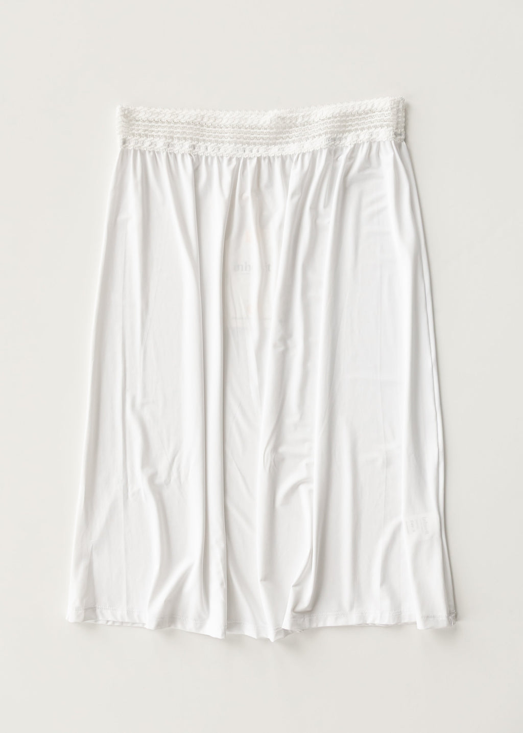 White half slip with elastic waistband and gathered skirt, mid-thigh length